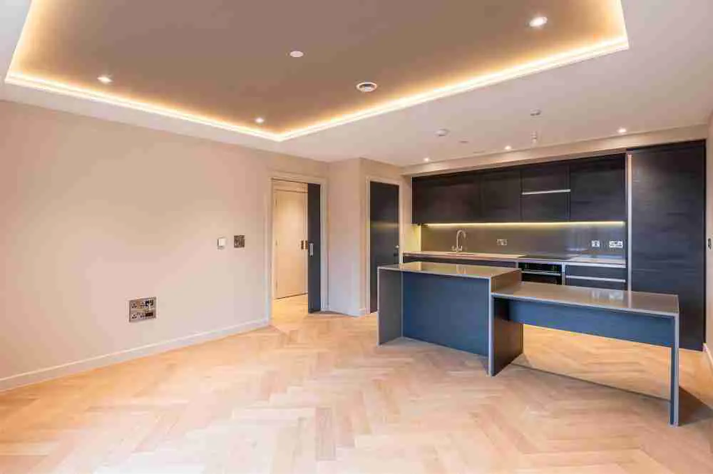 Caddick Construction - Kitchen Living Space with dark kitchen, wood finish worktop and herringbone flooring
